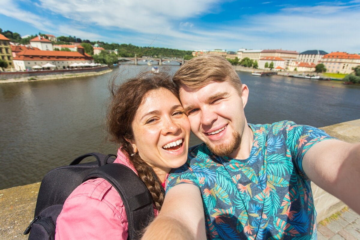 Happy young couple in love takes selfie portrait in Prague, Czech Republic. Pretty tourists make